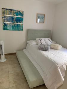 a bed with white sheets and pillows on it at Parque del Café - Apartasol 211 in La Tebaida