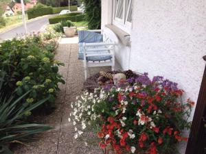 un giardino fiorito con una panchina e un mazzo di fiori di Gästehaus Stapf a Oberaurach