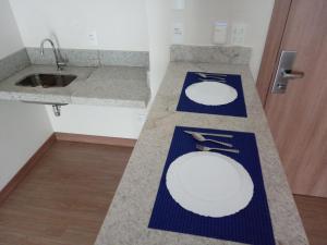 a bathroom with two white plates on a counter at Flat em Pedra Azul in Pedra Azul