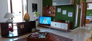 アルゲーロにあるVilla Paradiseの緑の壁のリビングルーム(テレビ付)