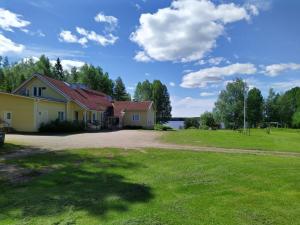 een huis met een grote tuin voor een meer bij B&B Aittoranta in Puolanka