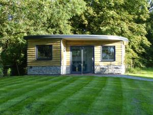a small cabin in a yard with a green lawn at Conkers - a new bespoke rural escape near Glastonbury in Glastonbury