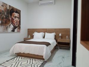 una camera da letto con un letto e un dipinto sul muro di Vía Real Hotel Boutique a Atotonilco el Alto