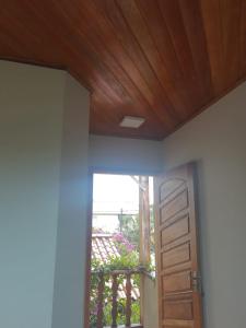 an open door to a balcony with a wooden ceiling at Suíte Verde in São Pedro da Aldeia