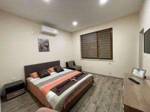 una camera con un letto e una televisione di Guest House Marchini a Sapareva Banya