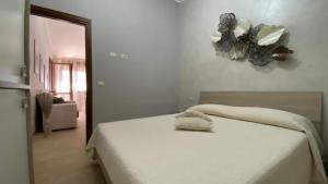 een wit bed in een kamer met een spiegel bij Casa vacanze Rebecca in Chia