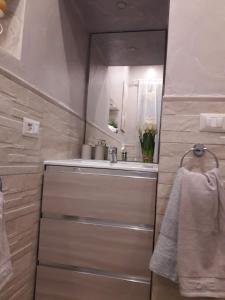 un bagno con lavandino e specchio di Casa vacanze Rebecca a Chia Altre 56 foto