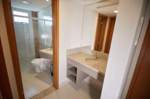 a bathroom with a sink and a toilet and a mirror at Resort do Lago Oficial in Caldas Novas