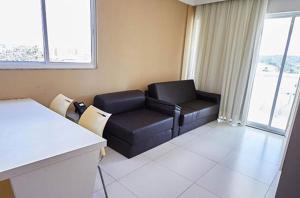 una sala de estar con un sofá de cuero negro en una habitación en Resort do Lago Oficial, en Caldas Novas