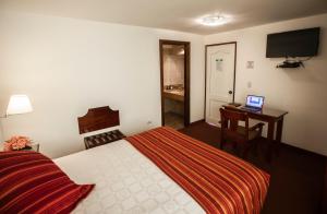 A bed or beds in a room at Hotel Hacienda Plaza de Armas