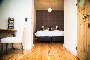 a bedroom with a bed and a wooden floor at B&B Chambres d'O in Ostend
