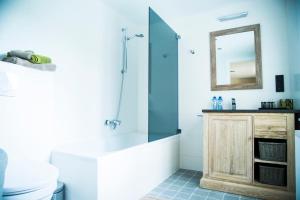a bathroom with a tub and a shower with a mirror at B&B Chambres d'O in Ostend