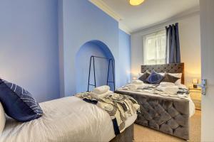 a blue bedroom with a bed and a window at Beautiful Victorian 2 Bedroom Flat in Leicester