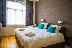 ein Schlafzimmer mit einem großen weißen Bett mit blauen Kissen in der Unterkunft B&B Chambres d'O in Ostende