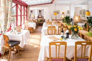 a restaurant with tables and chairs with white tablecloths at Hotel Sonnalm - SPA,Idyll,Dining in Bad Kleinkirchheim
