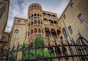 ein Gebäude mit einem Turm mit einem Zaun davor in der Unterkunft Residenza la Torretta in Venedig