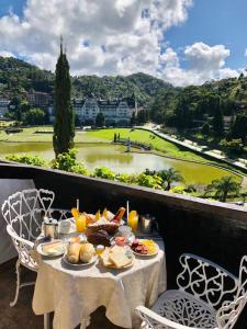 una mesa con comida en el balcón con vistas en Gallardin Palace Hotel, en Petrópolis