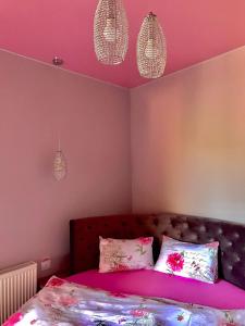 a bedroom with pink walls and a bed with pillows at Sweet Pink by Miro Apartment Early Checkin in Sinaia +52 photos