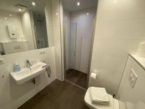 a white bathroom with a sink and a shower at City Apartments in Erfurt