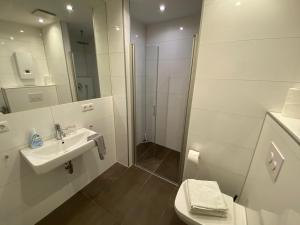 a white bathroom with a sink and a shower at City Apartments in Erfurt +17 photos