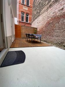 eine Terrasse mit einem Tisch und einer Bank an einer Ziegelwand in der Unterkunft City Apartments in Erfurt