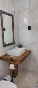 a bathroom with a white sink and a mirror at Chales Manaca da Serra in Urubici
