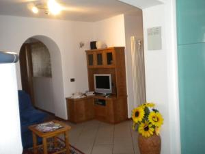 a living room with a television and a vase of flowers at B&B fam. Ausermiller in Castello di Fiemme