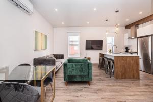 a kitchen and living room with a couch and a table at 2 Bedroom Luxury in the Mile End by Den Stays in Montréal