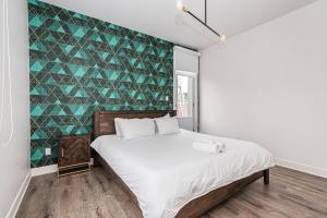 a bedroom with a bed with a green accent wall at 2 Bedroom Luxury in the Mile End by Den Stays in Montréal