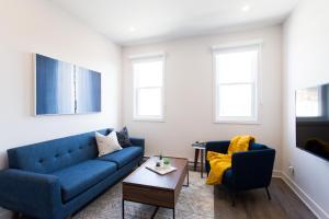 a living room with a blue couch and two chairs at Perfectly Located Mile End 2 Bdr Unit by Den Stays in Montréal