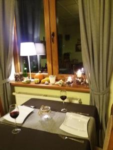 una mesa con dos copas de vino y una ventana en Dworek Zawadzkich, en Kruszyn