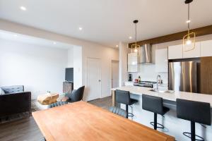een keuken en een woonkamer met een houten tafel bij Light Filled 2 Bdr Unit in Mile End by Den Stays in Montreal