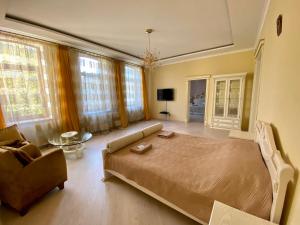 ein Schlafzimmer mit einem Bett, einem Sofa und einem Stuhl in der Unterkunft Royal Apartment in Lwiw