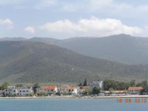 a town on the shore of a body of water with mountains at Hotel Prinos in Prinos