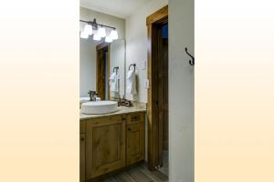 a bathroom with a sink and a mirror at Bear Claw 508 - True Ski-in Ski-out Access, Slope Views & Winter Shuttle! in Steamboat Springs +9 photos
