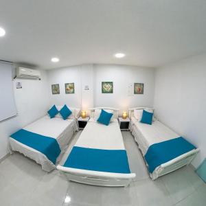 duas camas num quarto com azul e branco em Apartamentos Aury em San Andrés