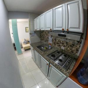 a small kitchen with a stove and a sink at Apartamentos Aury in San Andrés