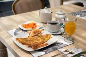 - une table avec une assiette de nourriture et une tasse de café dans l'établissement Ayenda Apart La Hacienda, à Piura