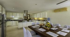 a kitchen with a wooden table and white cabinets at Villa Yoosook in Patong Beach