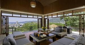 a living room filled with furniture and a large window at Villa Yoosook in Patong Beach