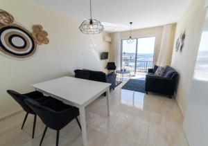 a living room with a white table and chairs at Castle apartment in Paphos City