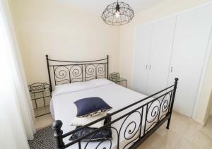 a bedroom with a black bed with a blue pillow at Castle apartment in Paphos City