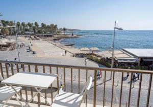 a balcony with a table and chairs and a beach at Castle apartment in Paphos City