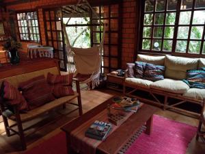 uma sala de estar com um sofá e uma mesa em Pousada Rosa & Canela na Praia do Rosa