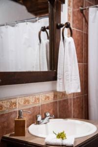 La salle de bains est pourvue d'un lavabo, d'un miroir et de serviettes. dans l'établissement Samay Kirutoa Lodge, à Quilotoa