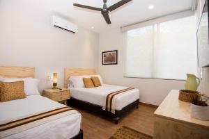 1 dormitorio con 2 camas y ventana en Tannah Luxury Rentals, en Mérida