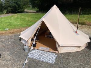 une grande tente blanche installée dans un champ dans l'établissement Dyfi Dens Machynlleth, à Esgair-geiliog