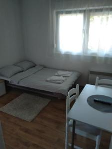 Zimmer mit einem Bett, einem Tisch und einem Fenster in der Unterkunft Apartman 2 Zagreb - Maksimir KBC Rebro in Zagreb