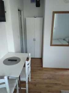 Zimmer mit einem weißen Tisch, Stühlen und einem Spiegel in der Unterkunft Apartman 2 Zagreb - Maksimir KBC Rebro in Zagreb