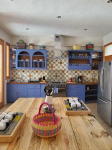 a kitchen with blue cabinets and a wooden table at Casa Carmen in San Cristóbal de Las Casas